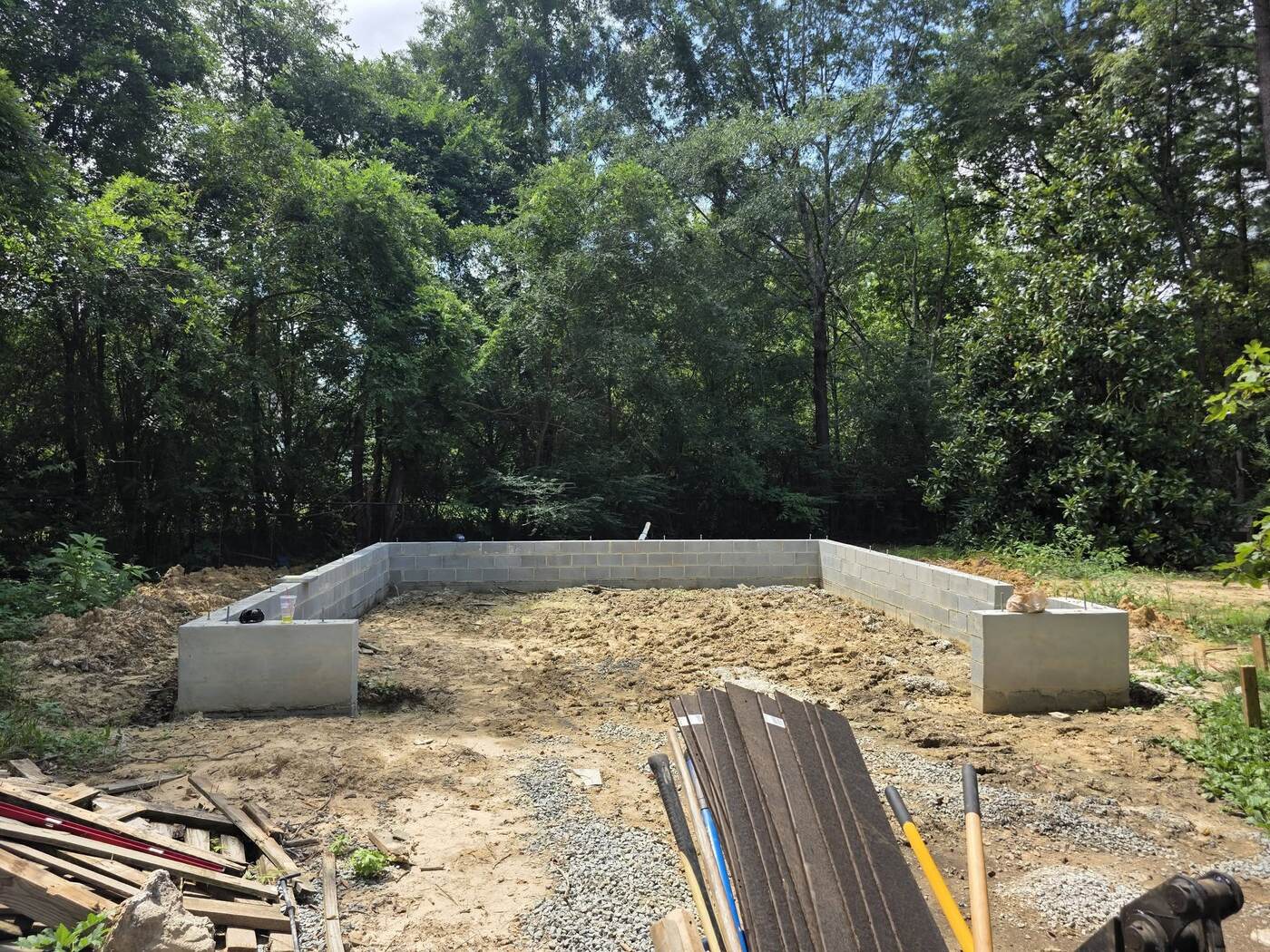 Before: Rough, uneven clay subgrade inside garage foundation walls
